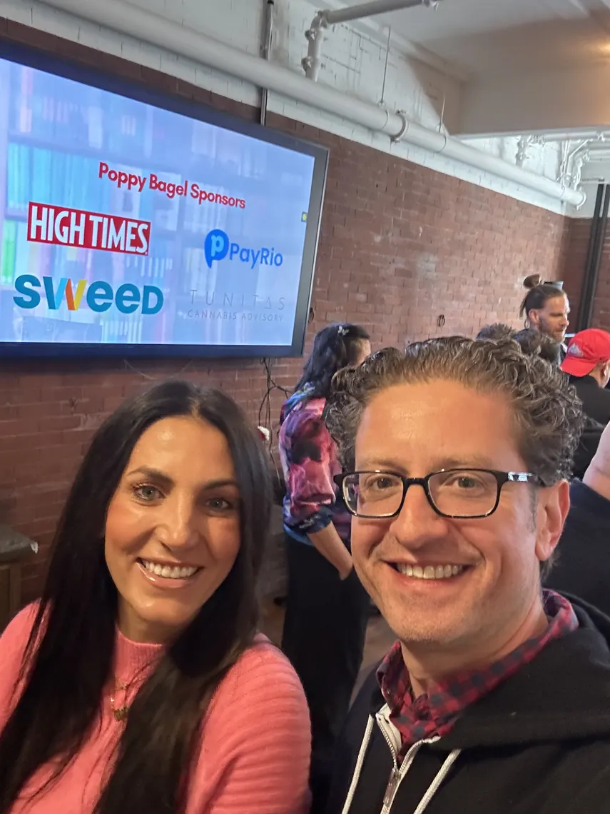 Jordan Isenstadt with a guest in front of the sponsor screen showing High Times, Sweed and PayRio