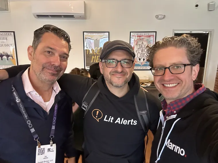 Jordan Isenstadt with two guests, one in a Lit Alerts shirt
