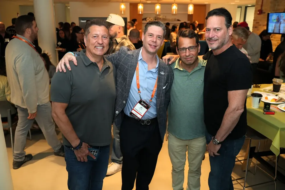 Five attendees posing arm in arm at the IgniteIt Chicago Bagel Bash