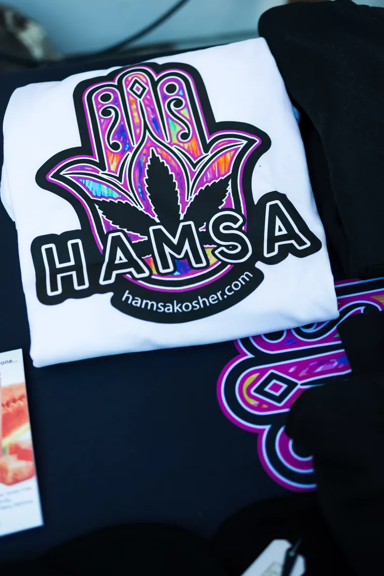Hamsa Kosher t-shirt laid out on a vendor table