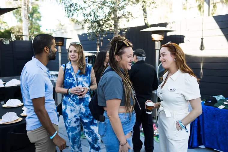 Four attendees chatting near the patio tables
