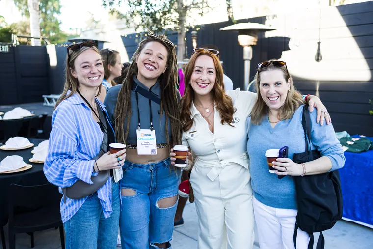 Four women posing together with coffee cups at the Ventura Bagel Bash