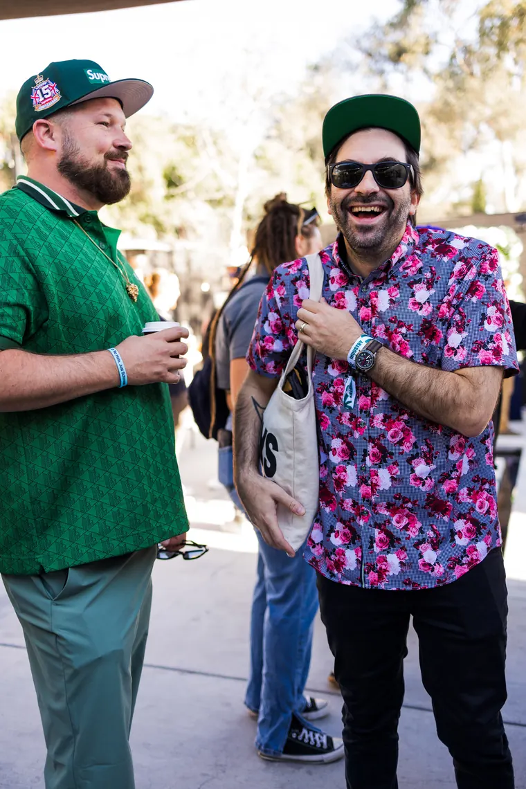 Two guests in baseball caps laughing on the patio