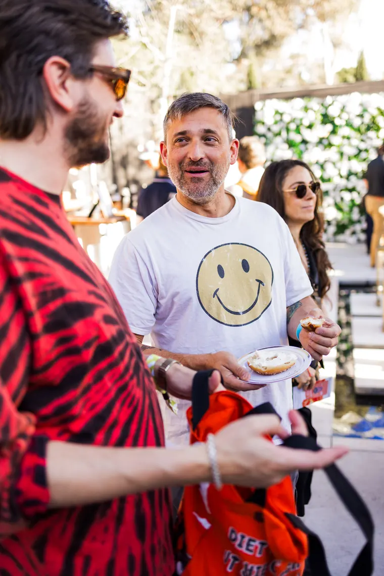 Two attendees laughing, one in a smiley face t-shirt