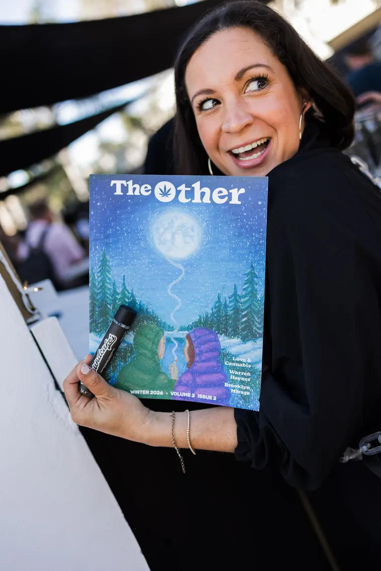 Guest smiling over a copy of The Other magazine