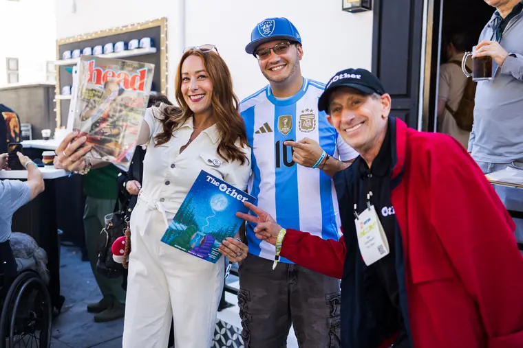 Four friends posing with vintage magazines and a copy of The Other