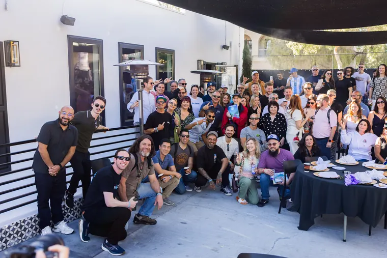 Second group shot with the crowd crouching and waving at the camera