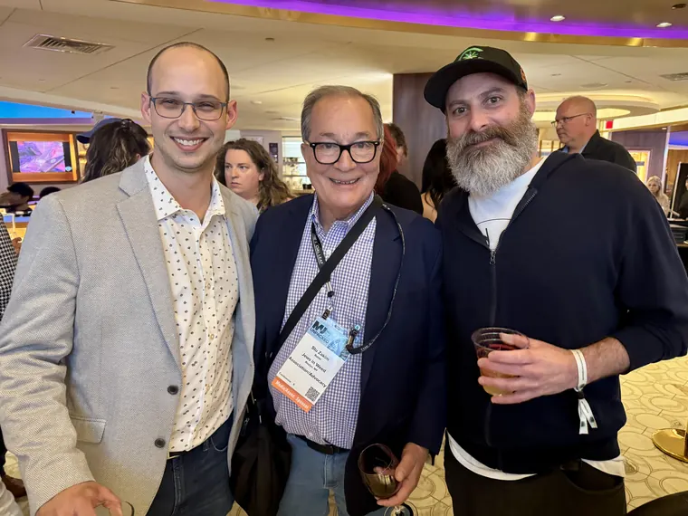Three attendees with drinks in hand